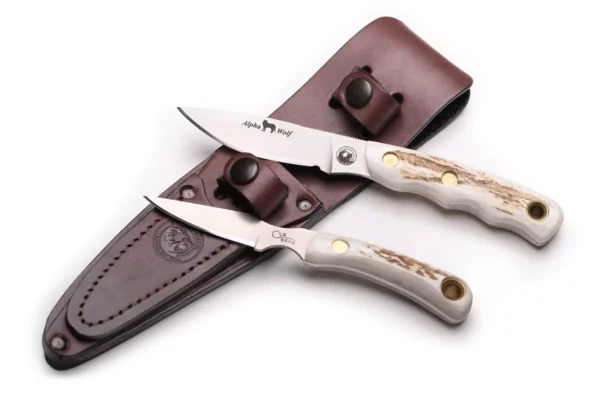 Alpha Wolf and Cub Bear knives with stag handles displayed above a leather sheath