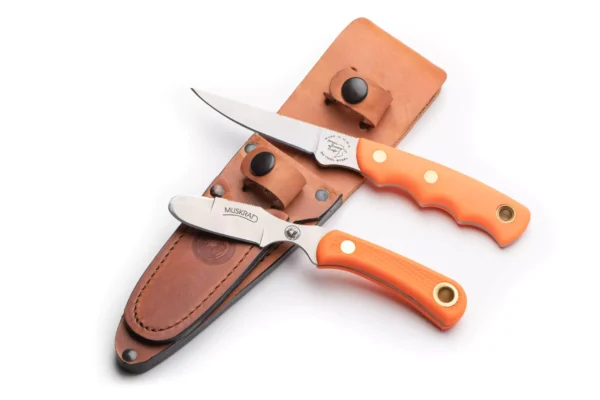 Jaeger and Muskrat knives with orange Suregrip handles displayed beside leather sheath.